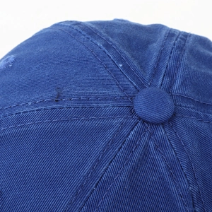 Close-up of navy blue baseball cap top crown with stitched seams and button detail