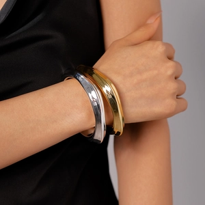 Irregular wavy metal acrylic cuff bracelets in polished gold and silver finishes