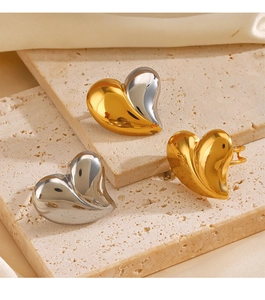 Dettaglio di tre orecchini a cuore nelle finiture oro, argento e bicolore combinati