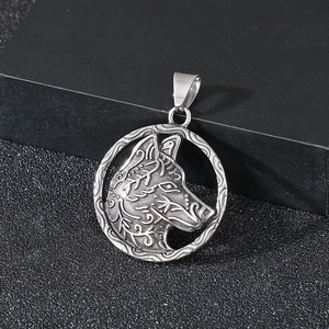 Macro detail of silver stainless steel viking wolf head pendant on a dark background