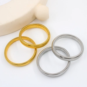 Detailed view of flexible gold and silver snake-style spiral texture metal bracelets