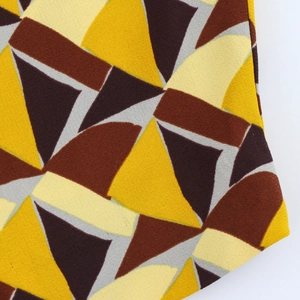 Vista de detalle del tejido con estampado geométrico en colores amarillo, marrón y gris