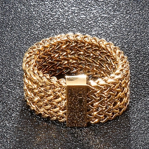 Detail of golden woven mesh ring featuring a smooth rectangular plate on black background