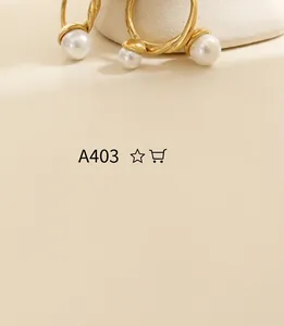 Close-up of twisted 18K gold plated C-shape earrings with elegant white pearls