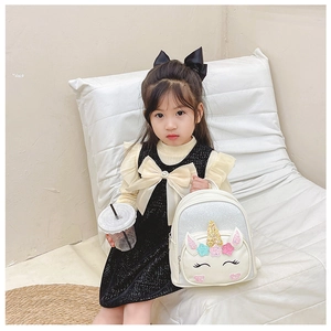 Close-up of a little girl wearing the white glitter unicorn backpack with sequins