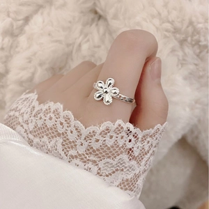 Adjustable S925 sterling silver ring with small flower design for women on a plush background