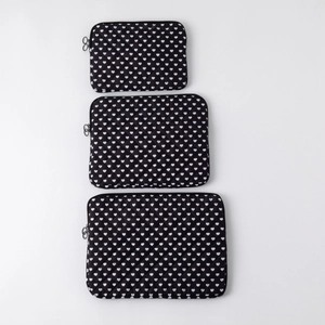 Three-piece set of black quilted laptop sleeves with white heart pattern and zippers