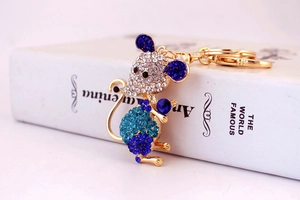 Macro shot of mouse keychain with sparkling blue and white rhinestones and gold plating