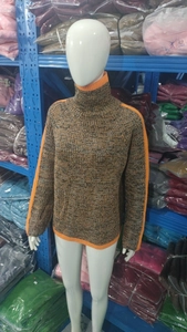 Detail of high turtleneck chunky knit sweater in grey with contrast orange edge trim