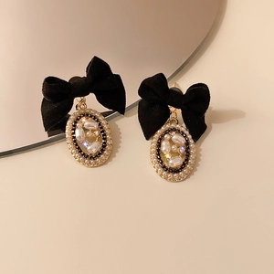 Detail of vintage bow earrings with velvet bow and pearl pendant with crystals