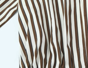 Gros plan sur la texture en coton à rayures verticales marron et blanc de la chemise