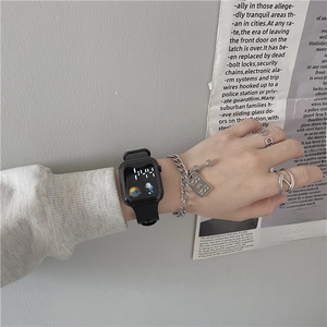 Minimalist digital sports watch with silver chain bracelet and rings on neutral background
