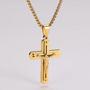 Detail of gold cross pendant with Jesus relief carving on a sleek metallic chain