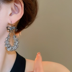 Nahaufnahme von Diamant-Schleifenohrringen mit Kristallperlen für einen schicken Look