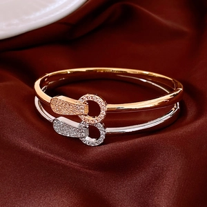 Détail de joncs plaqués or 18 carats avec cristaux de zircon sur tissu en soie rouge