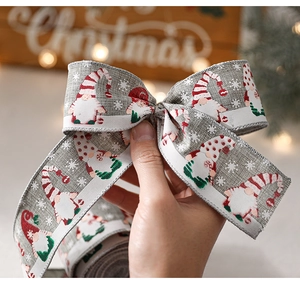 Détail d'un ruban de Noël avec motif de gnomes noué en boucle pour la décoration