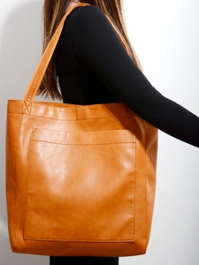 Détail du sac cabas vintage en cuir PU orange avec une grande poche avant pratique