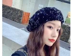 Close-up of black sequined beret hat showing high-density reflective material on model