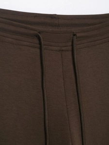 Detail of dark brown elastic waistband with drawstring on knit flared trousers