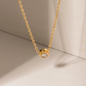Minimalist gold titanium steel necklace with a round bezel-set cubic zirconia pendant