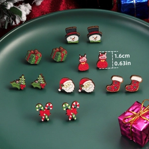 Close-up of a 7-piece Christmas stud earring set featuring Santa, snowmen, and trees