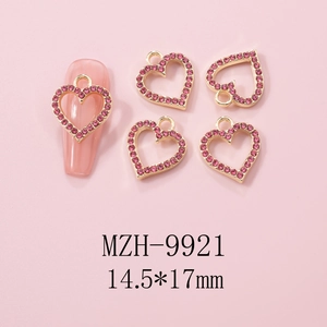 Detailed view of pink heart nail charms with gold alloy base and rhinestones