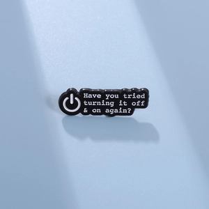 Détail du pin's en émail noir avec texte blanc humoristique sur fond bleu texturé
