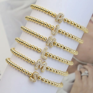Gold bubble letter bracelets with sparkling zircon charms on stretch beaded bands