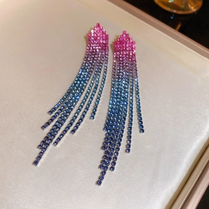 Detailed view of long tassel earrings with pink and blue gradient zircons on satin