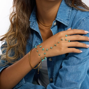 Detail of 18K gold-plated hand chain featuring irregular turquoise stones on a model hand
