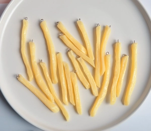 Dettaglio di ciondoli realistici a forma di patatine fritte in resina con anelli di metallo