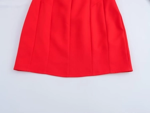 Detail of red A-line bubble hem mini dress with vertical stitching and smooth texture