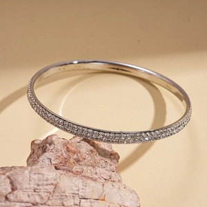 Detailed close-up of a silver-toned bangle with double rows of pave-set cubic zirconia