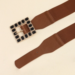 Detail of a brown elastic belt featuring a square buckle with black rhinestones inlay