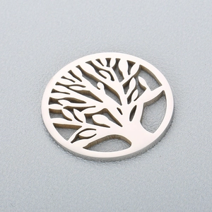 Polished silver stainless steel Tree of Life hollow pendant on a textured background