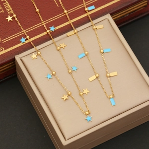 Detail of gold chain necklaces with light blue star pendants and enamel bars on a stand
