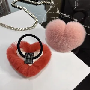 Plush heart-shaped hair scrunchies in red and pink faux rabbit fur with handmade label
