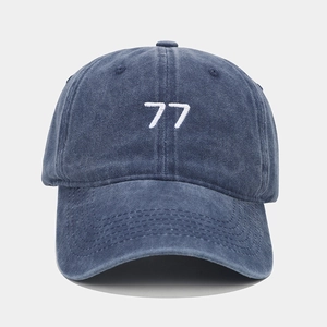 Détail du coton délavé bleu et de la broderie blanche chiffre 77 sur la casquette