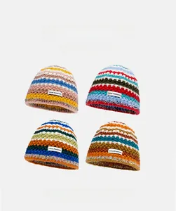 Detail view of colorful striped knit beanies in four vibrant winter color combinations