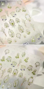 Détail macro d'autocollants pour ongles muguet gaufrés avec texture dorée brillante