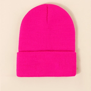 Detailed close-up of vibrant neon pink knitted beanie with folded cuff design