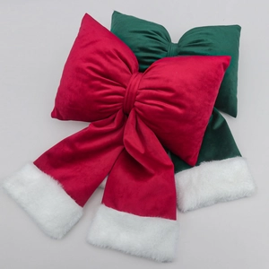 Detail of red and green velvet Christmas bow pillows with soft white faux fur trim