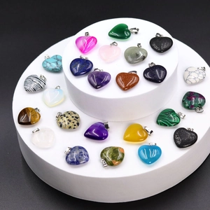 Macro view of assorted heart-shaped natural stone pendants on a white display stand