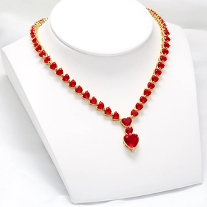Exquisite gold necklace with a sequence of red heart-shaped rubies on a white stand