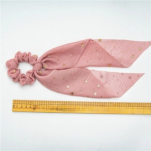 Pink chiffon scrunchie with gold star patterns and long flowing ribbon hair accessory