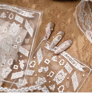 Macro detail of white embossed lace nail stickers with vintage pearl and floral pattern
