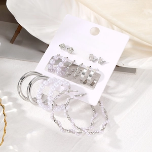 Detail of 9-pair silver butterfly and pearl earring set on fashion jewelry display card