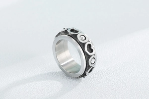 Vue macro d'une bague rotative en acier avec motifs de cœur en zircon et fini vintage