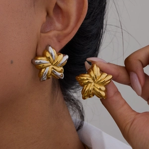 Twisted flower stud earrings in gold and silver finish on model showing design details