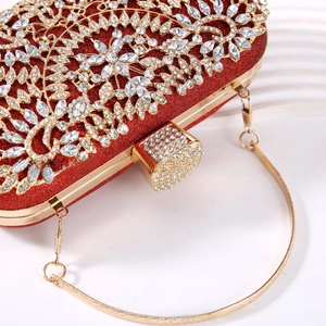 Macro shot of red evening clutch featuring intricate crystal floral patterns and gold metal frame